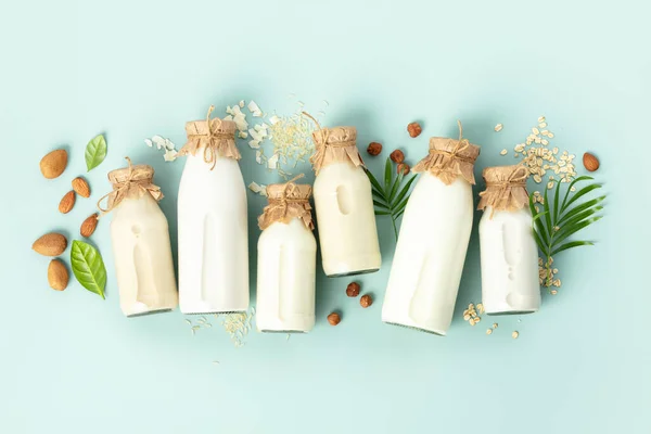 トルコ石の背景にボトルや材料で非酪農植物ベースの牛乳。代替乳糖フリーミルク代用品、フラットレイ — ストック写真