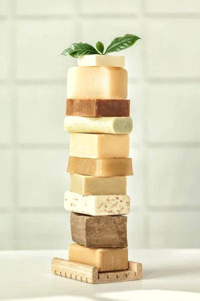 Stack of assorted natural soap bars on white bathroom countertop — Stock Photo, Image