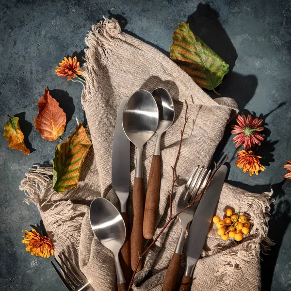 Autumn thanksgiving table place setting concept. Beautifull cutlery and autumn leaves on vintage background — Stock Photo, Image