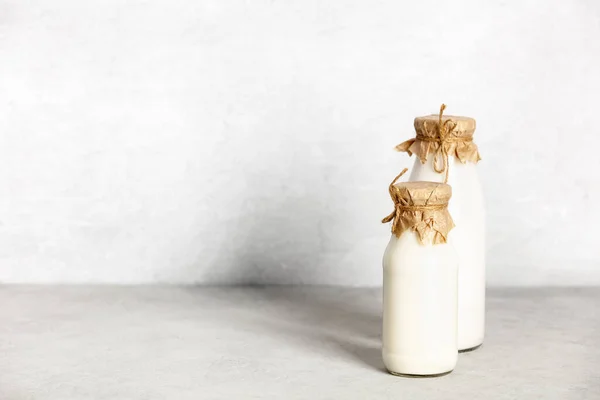 Milch auf pflanzlicher Basis in Flaschen und Zutaten auf hellem Hintergrund. Alternative laktosefreie Milchprodukte — Stockfoto