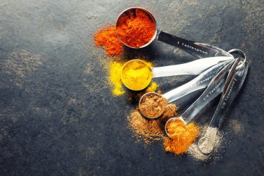 metal kaşık içinde renkli baharatlar 