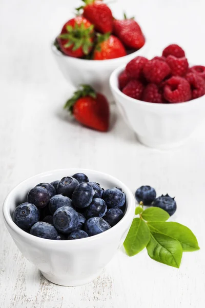 Beeren in Schalen auf Holzgrund. — Stockfoto