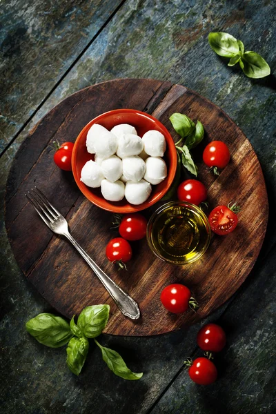 Tomates cherry, hojas de albahaca, queso mozzarella y aceite de oliva —  Fotos de Stock