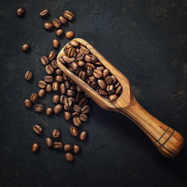 Grains de café et une vieille cuillère en bois — Photo