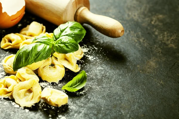 Tortellini italiano cru caseiro e folhas de manjericão — Fotografia de Stock