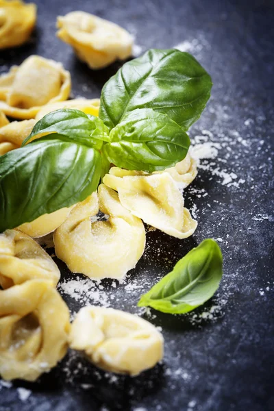 Domácí syrové italské torteliny a listy bazalky — Stock fotografie