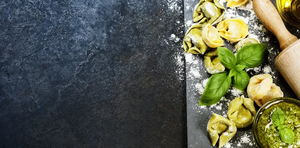 Tortellini italiano crudo casero y hojas de albahaca —  Fotos de Stock