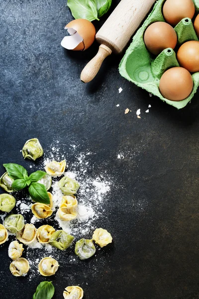 Tortellini italiano crudo casero y hojas de albahaca — Foto de Stock