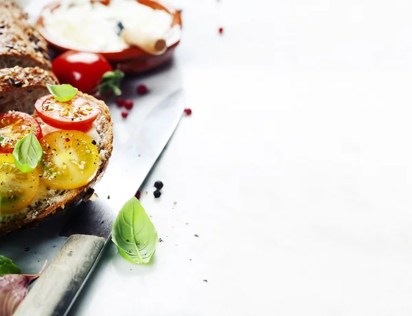 Delicious sandwich with slices of tomatoes and basil — Stock Photo, Image