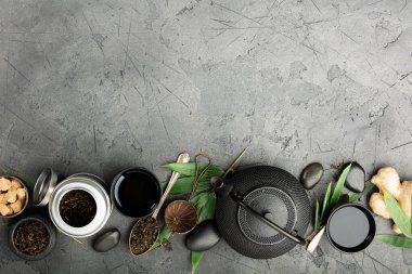 Geleneksel çaydanlık, çay fincanları, zencefil ve yeşil yapraklar.