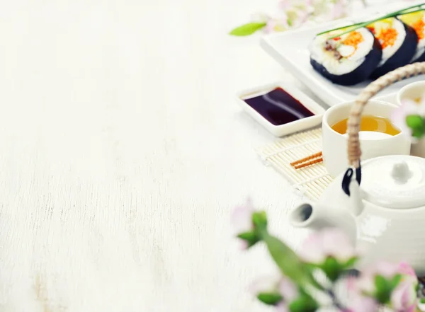 Суші набір, зелений чай і гілка сакури — стокове фото