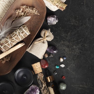 Bilge, şifalı kristaller, mumlar ve bitkilerden oluşan bir kolleksiyon bütünsel, ruhani bir ortam için karanlık, kırsal bir yüzeye yerleştirilmiş..