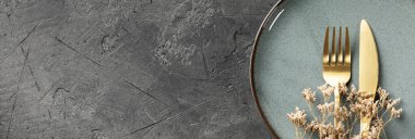 Modern mat-altın çatal bıçak takımı, klasik gümüş çatal bıçak takımı, seramik tabaklar, yüzüklü peçeteler, kurutulmuş çiçekler, yeşil aksanlar, baharatlar, biberler, kaba tuz, kurutulmuş kırmızı biber, yıldız anason, n