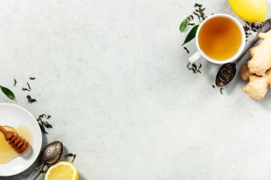 Hafif bir yüzey üzerinde zencefil, limon, bal ve gevşek çay yapraklarıyla sade bir bitki çayı seti, sağlık, sağlık ve yaşam tarzı temaları için ideal..