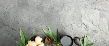 Geleneksel siyah çaydanlık, çay fincanları, zencefil ve yeşil yapraklar fotokopi alanı, menüler, spa ya da çay markaları için mükemmel olan koyu renkli taş yüzeyde..