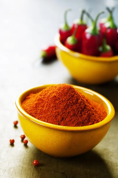 Paprika in een kom en hot chili peppers — Stockfoto