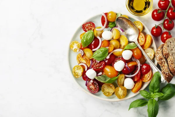 Färska tomater med basilika bladen i en skål — Stockfoto