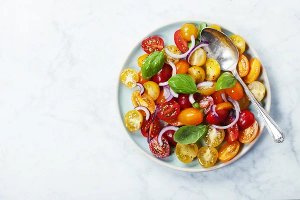 Fresh tomatoes with basil leaves in a bowl — Stock Photo, Image