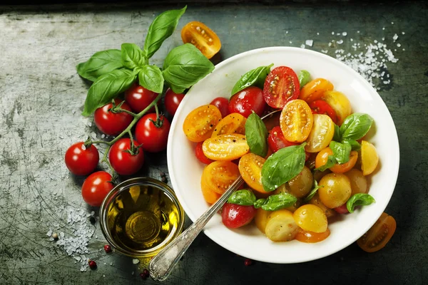 Tomates frescos com folhas de manjericão em uma tigela — Fotografia de Stock