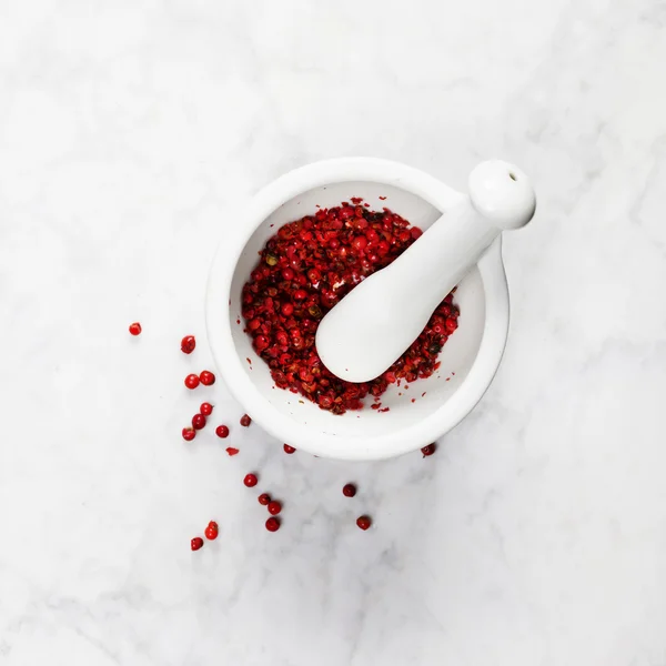 Mortar and pestle with red peppercorns — Stock Photo, Image