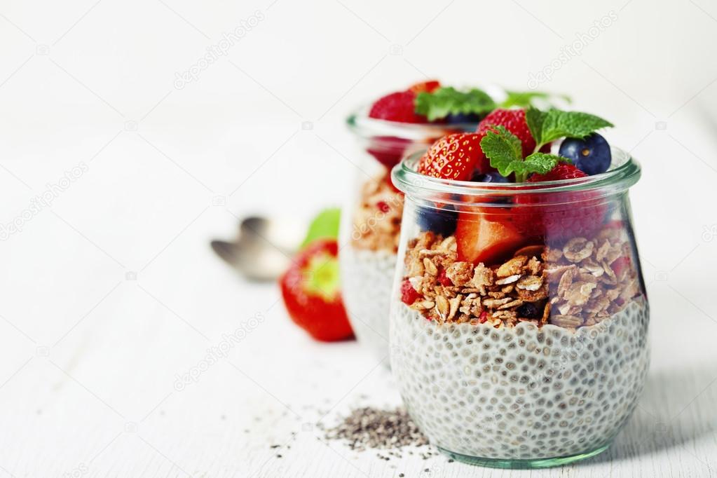 Chia seeds vanilla pudding and berries on wooden rustic backgr