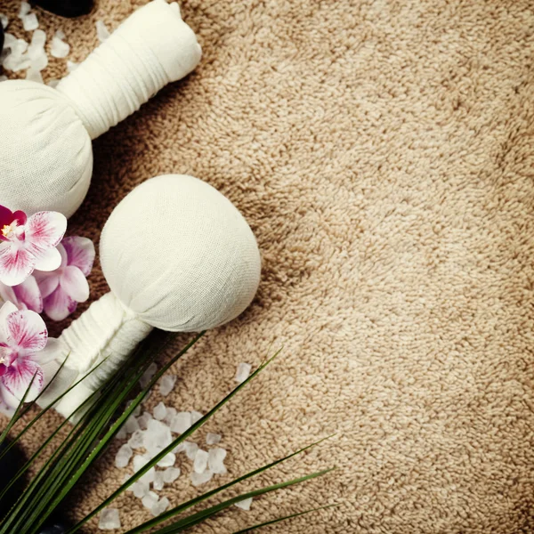 Spa background (pink orchid, herbal compress stamps, sea salt, towel and massage stones) — Stock Photo, Image