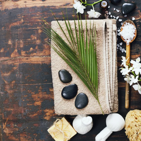 Spa background (white orchid, herbal compress stamps, sea salt, towel, candle and massage stones) — Stock Photo, Image