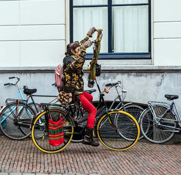 NETHERLANDS, UTRECHT - OCTOBER 25, 2015: Modern Dutch hippie ride by bicycle on downtown. October 25, 2015 in Utrecht - Holland. — Stock Photo, Image