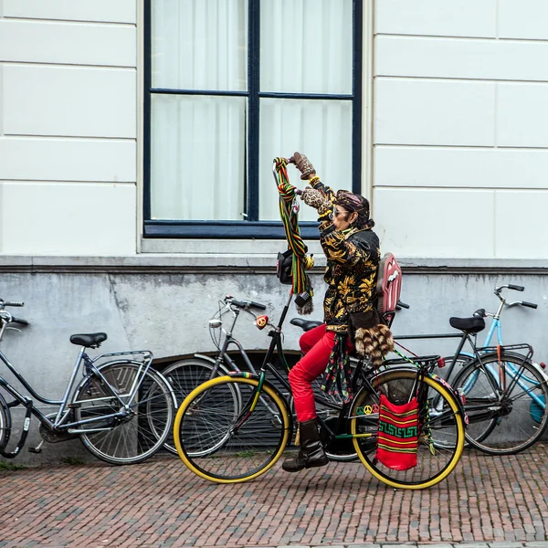 NETHERLANDS, UTRECHT - OCTOBER 25, 2015: Modern Dutch hippie ride by bicycle on downtown. October 25, 2015 in Utrecht - Holland. — Stock Photo, Image