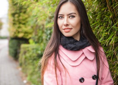 Çekici genç kadın kadar güzel saçlar açık pembe ceket poz giyinmiş.