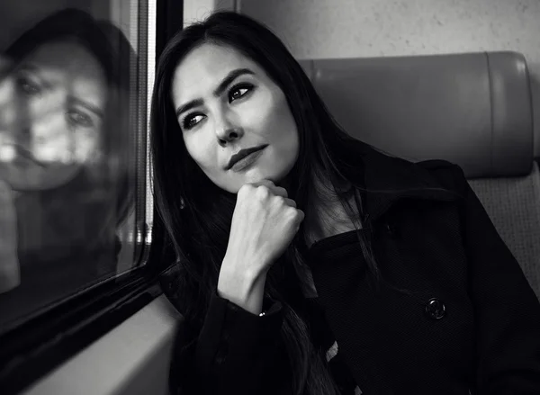 Πορτρέτο του όμορφη νεαρή γυναίκα με μακριές τρίχες που κοιτάζει έξω από το παράθυρο του τρένου. — Φωτογραφία Αρχείου