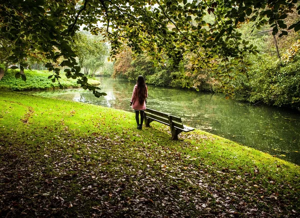 Attraktive junge Frau mit langen schönen Haaren gekleidet rosa Mantel posiert im Freien. — Stockfoto