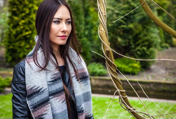 Attractive young friendly woman with long beautiful hairs posing in park. — Stock Photo, Image