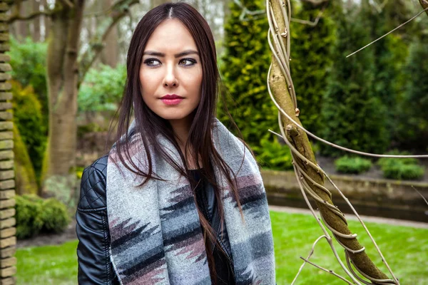 Attractive young friendly woman with long beautiful hairs posing in park. — Stock Photo, Image