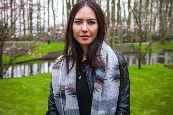 Attrayant jeune femme avec de longs beaux poils posant dans la serre de fleurs du parc Keukenhof . — Photo