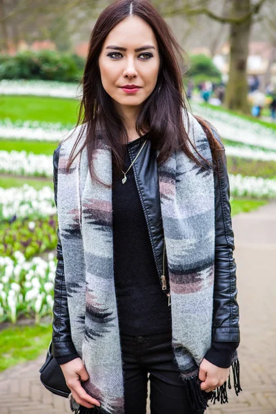 Attrayant jeune femme avec de longs beaux poils posant dans la serre de fleurs du parc Keukenhof . — Photo