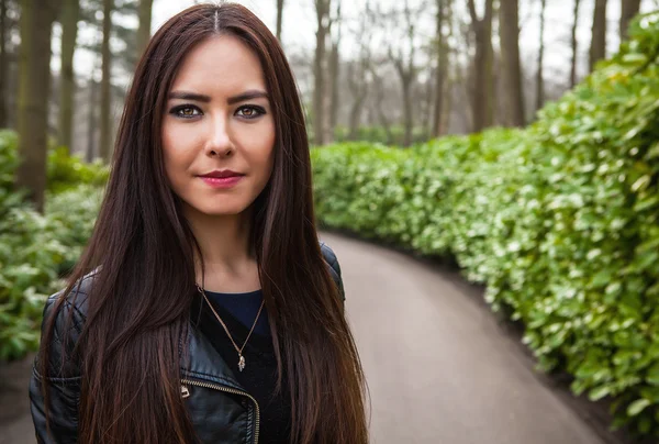 Attrayant jeune femme avec de longs beaux poils posant dans la serre de fleurs du parc Keukenhof . — Photo