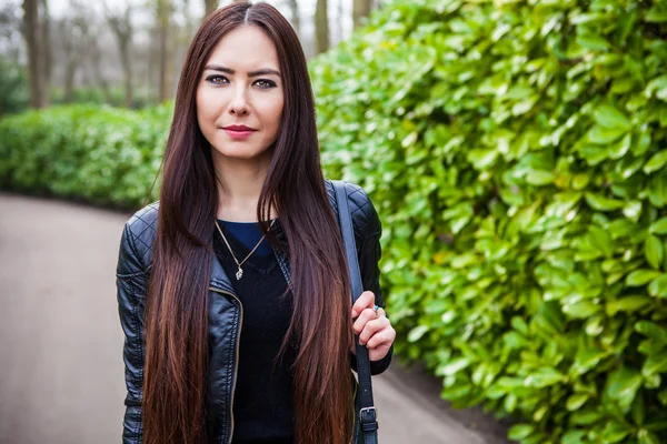 Attrayant jeune femme avec de longs beaux poils posant dans la serre de fleurs du parc Keukenhof . — Photo