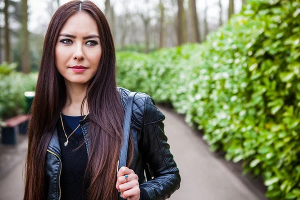 Attraktiv ung kvinna med långa vackra hår poserar i blomma växthusgaser Keukenhof parken. — Stockfoto