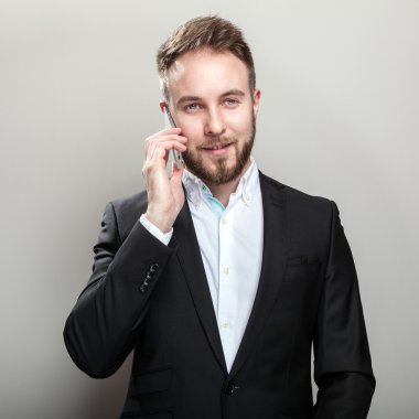 Zarif genç yakışıklı adam klasik siyah kostüm ve beyaz gömlek içinde sakallı.