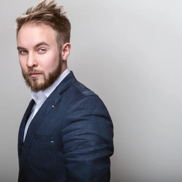 Homem bonito jovem elegante em traje azul escuro clássico. Estúdio retrato de moda . — Fotografia de Stock