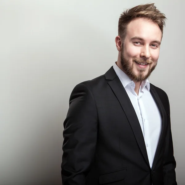 Elegant young handsome bearded man in classic black costume & white shirt. — Stock Photo, Image