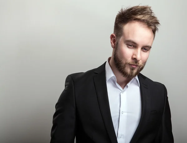 Elegante jovem bonito barbudo homem em traje preto clássico e camisa branca . — Fotografia de Stock