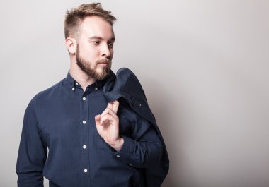 Koyu mavi klasik gömlek ve ceket omzunun üstünde zarif genç yakışıklı adam. Studio moda portre.