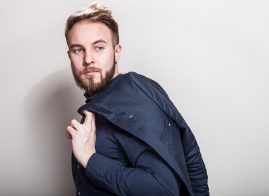 Koyu mavi klasik gömlek ve ceket omzunun üstünde zarif genç yakışıklı adam. Studio moda portre.