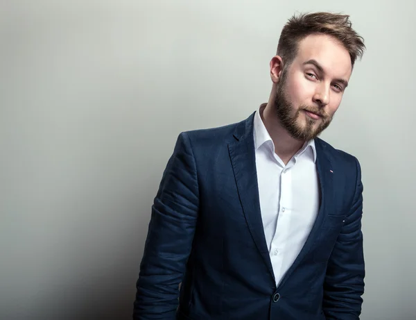 Elegante jonge knappe man in klassieke donker blauwe kostuum. Studio mode portret. — Stockfoto