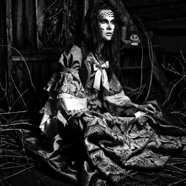 Fine art photo of young woman on ancient dress in a dark mystic wonderland location.  clipart