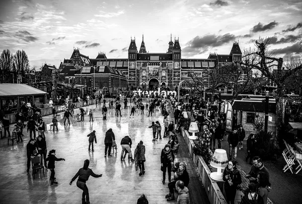 Amsterdam, Nederland - 15 januari 2016: Veel mensen schaatsen op winter schaatsen ijsbaan tegenover het Rijksmuseum, een populaire toeristische bestemming in Amsterdam, Nederland. — Stockfoto