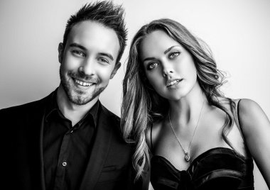 Portre studio poz genç çekici çift siyah moda kıyafetler giymiş. Siyah-beyaz fotoğraf.