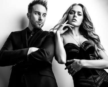 Portre studio poz genç çekici çift siyah moda kıyafetler giymiş. Siyah-beyaz fotoğraf.